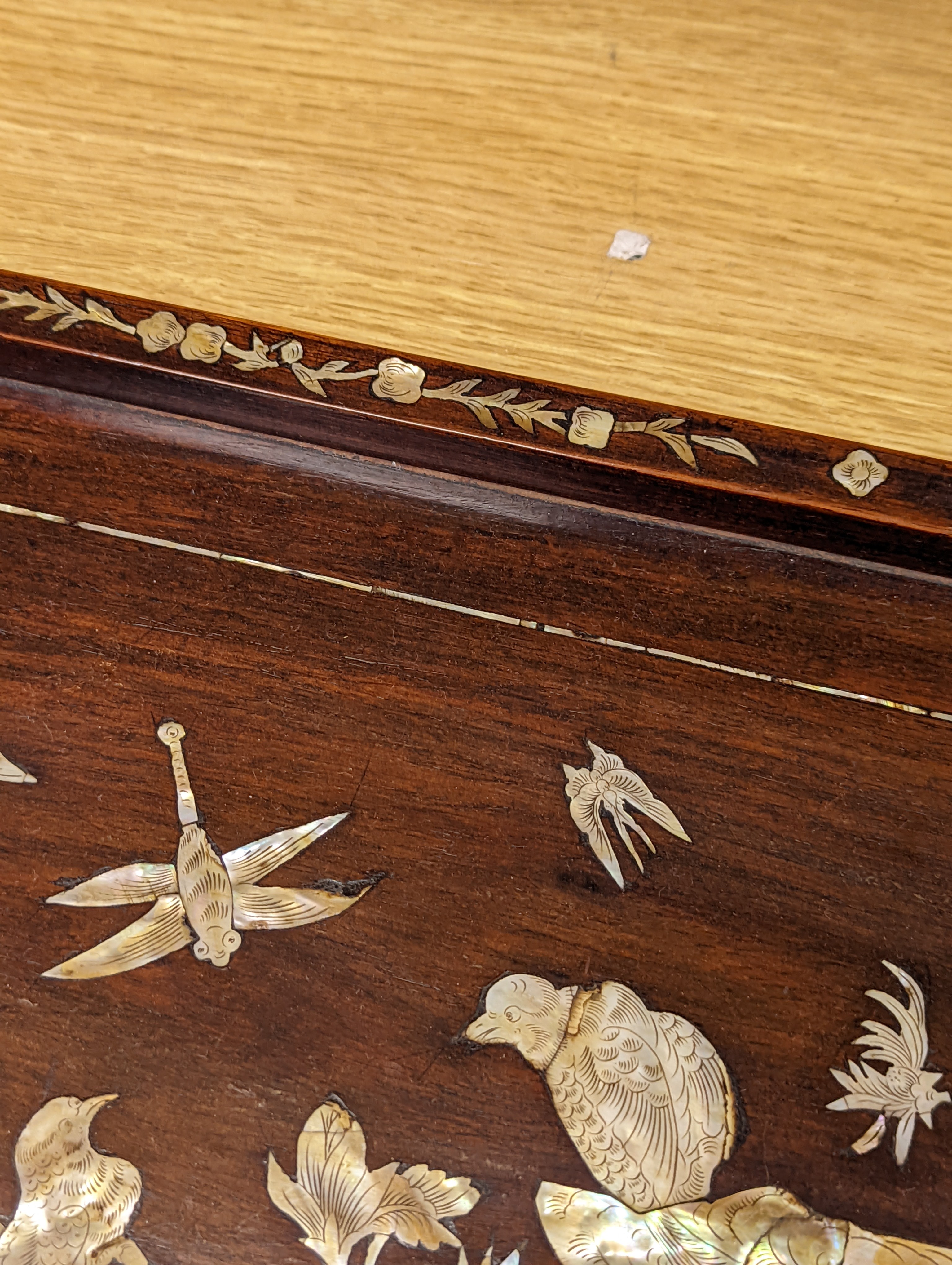 Two Chinese mother of pearl inlaid hongmu trays, the rectangular example with birds and insects amid flowers and the smaller oval example with a pavilion in a landscape within floral sprays 55x34cm